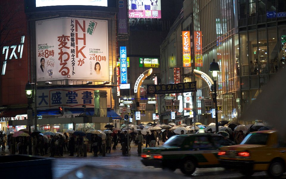 Pedestrians with umbrellas at Shibuya Crossing in Tokyo on a rainy day in 2010